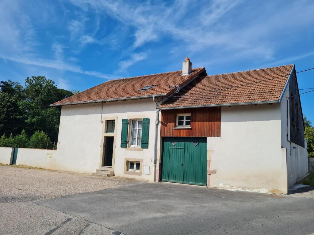 a white and green garage with a green door at Gîte Lunéville, 3 pièces, 4 personnes - FR-1-584-293 in Lunéville