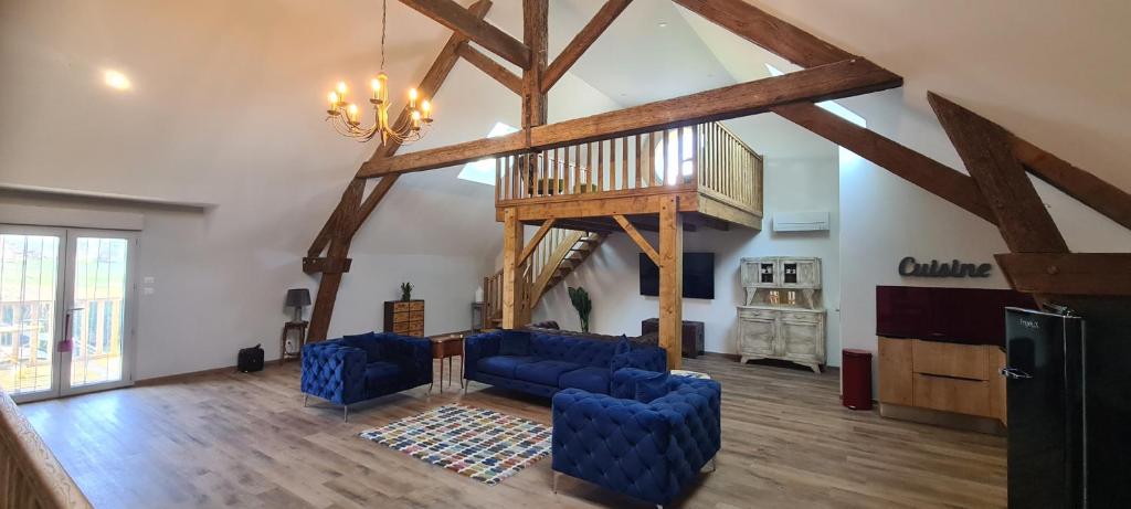 een woonkamer met blauwe banken en een trap bij Modern, spacious 2 bed riverfront apartment with pool for 4-6 people in Lamonzie-Saint-Martin