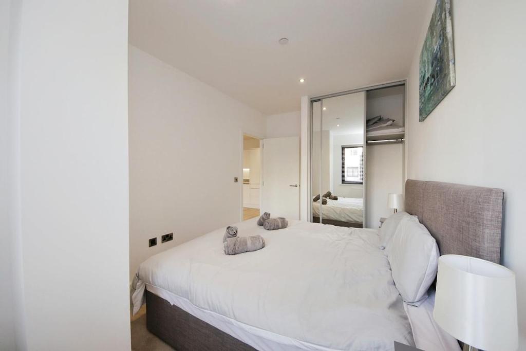 索利赫爾的住宿－Modern Comfort: Seven Stays Broadoaks，卧室配有一张白色大床和镜子
