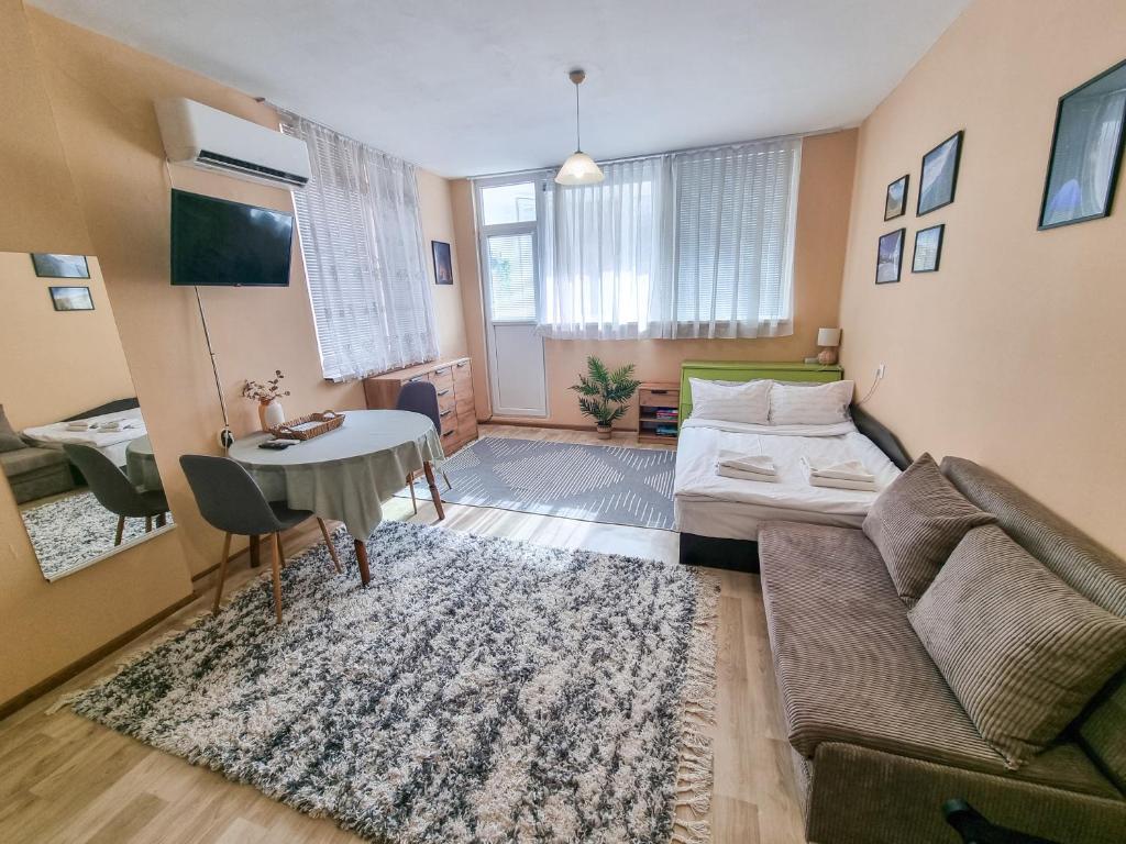 a living room with a couch and a table at Студио апартамент Троян in Troyan