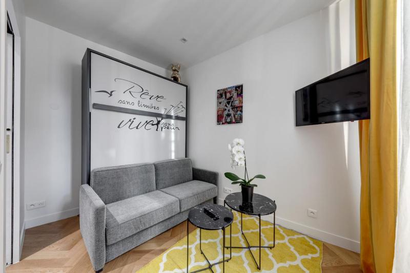 ein Wohnzimmer mit einem Sofa und einem TV in der Unterkunft 213 Suite Givenchy - Superb apartment in Paris in Paris
