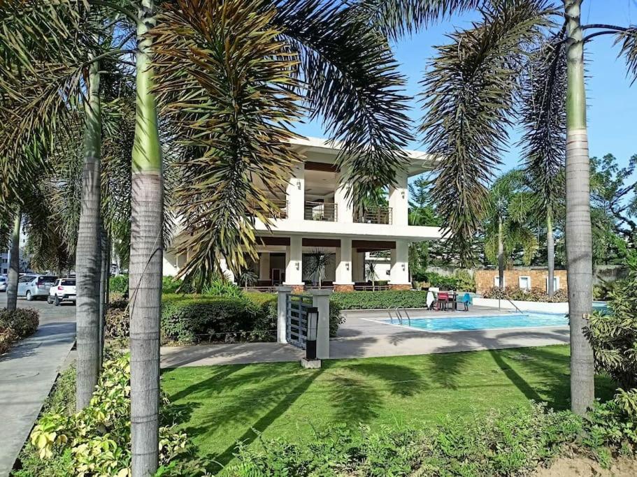 une maison avec des palmiers devant elle dans l'établissement Tim's 2BR / 1T&Bath 8 Spatial Condo Maa Davao City, à Davao