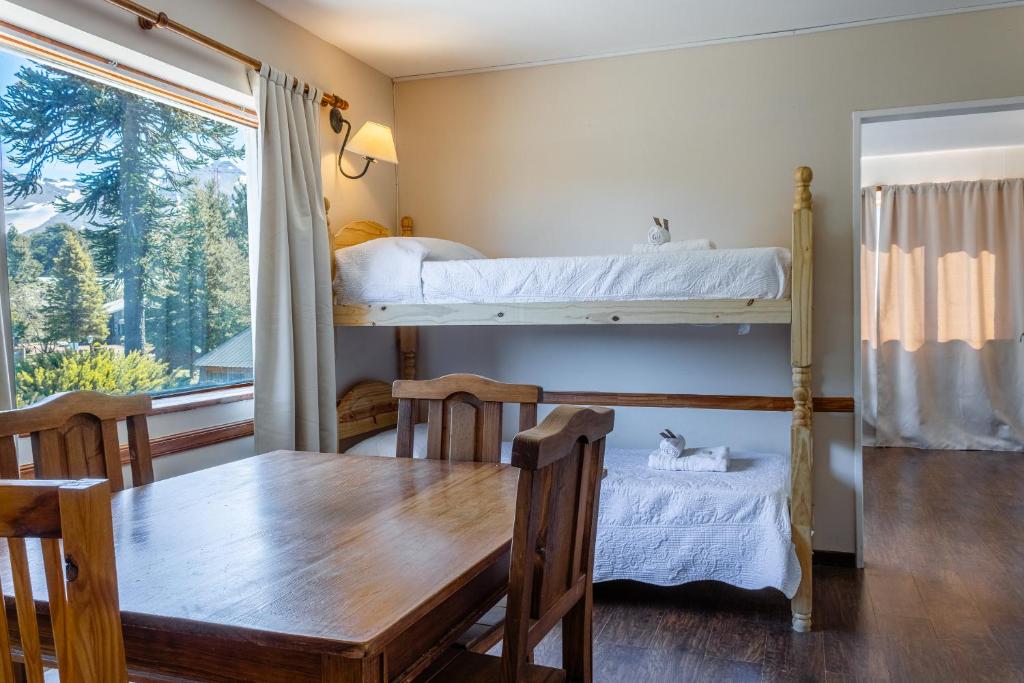 jadalnia ze stołem i łóżkiem piętrowym w obiekcie Hotel Kallfu by Nordic w mieście Caviahue
