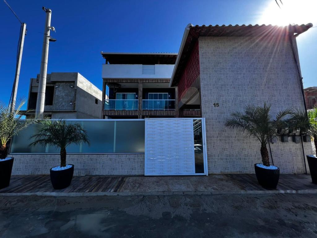 una casa con palmeras delante en Águas Rasas - Flats en Arraial do Cabo