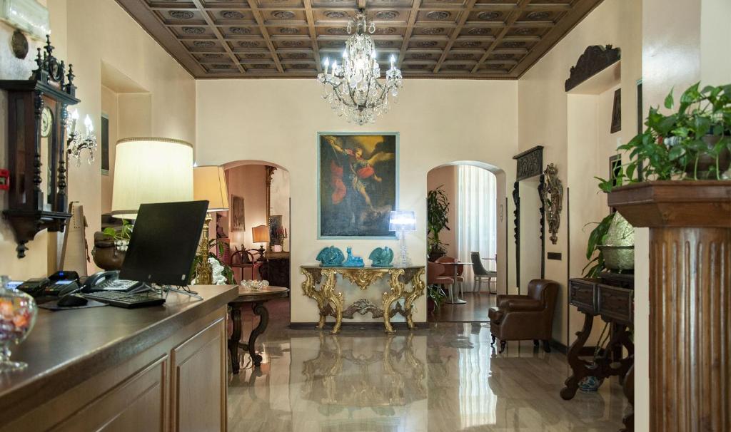 un ampio soggiorno con tavolo e lampadario a braccio di Hotel San Guido a Milano