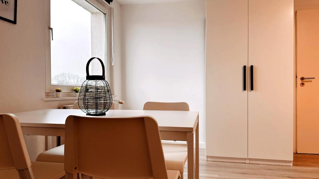 d'une salle à manger avec une table, des chaises et une fenêtre. dans l'établissement Exklusive Wohnung für Monteure in Bochum, à Bochum