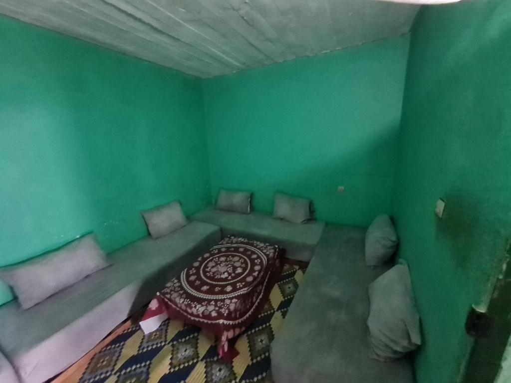 een kamer met een bed in een groene kamer bij Gite Ain Bechar in Taza