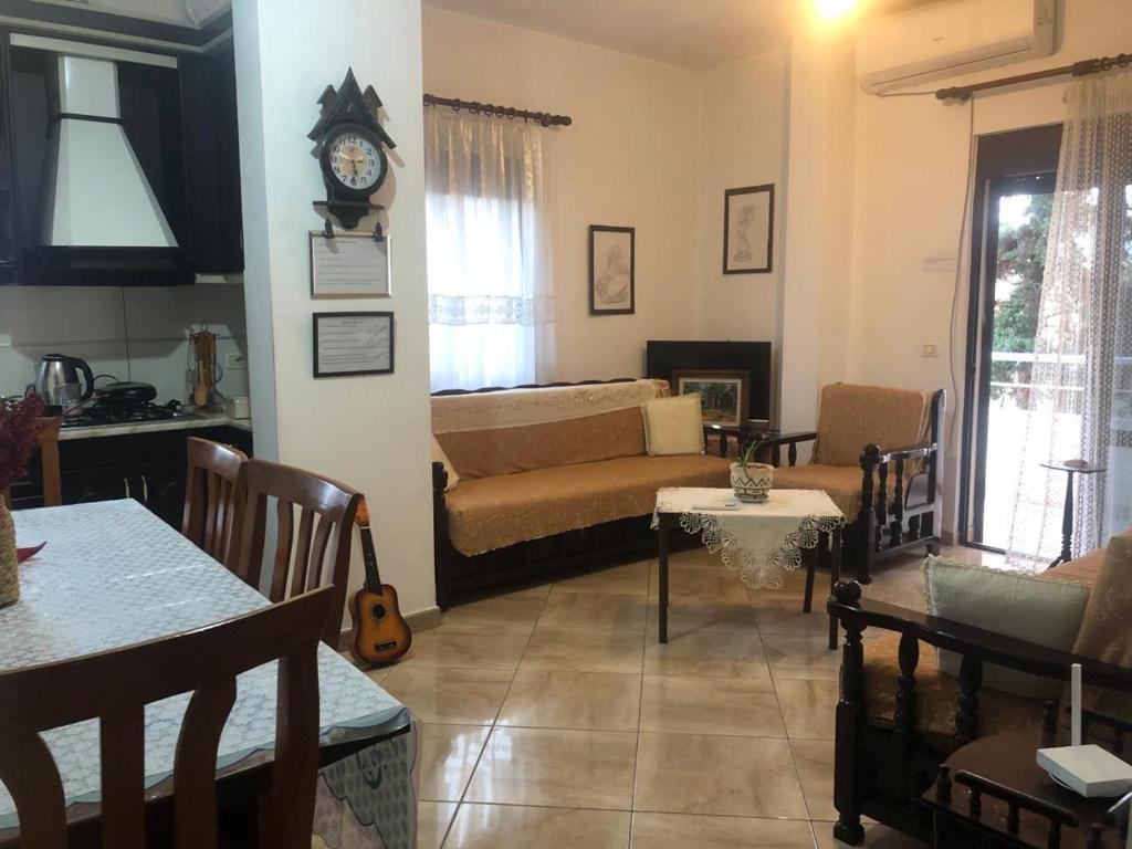 a living room with a couch and a clock on the wall at Tafilaj Apartments in Durrës