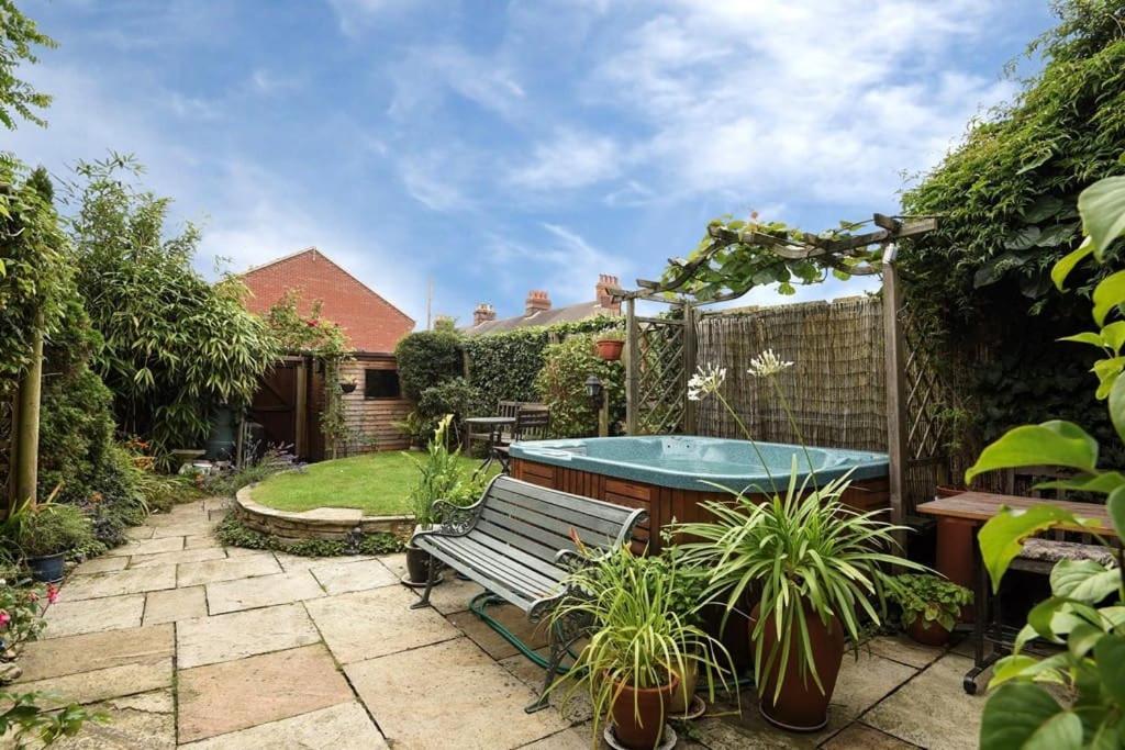 a garden with a bench and a hot tub at Large character home, hot tub, beach 5 min walk in Gorleston-on-Sea