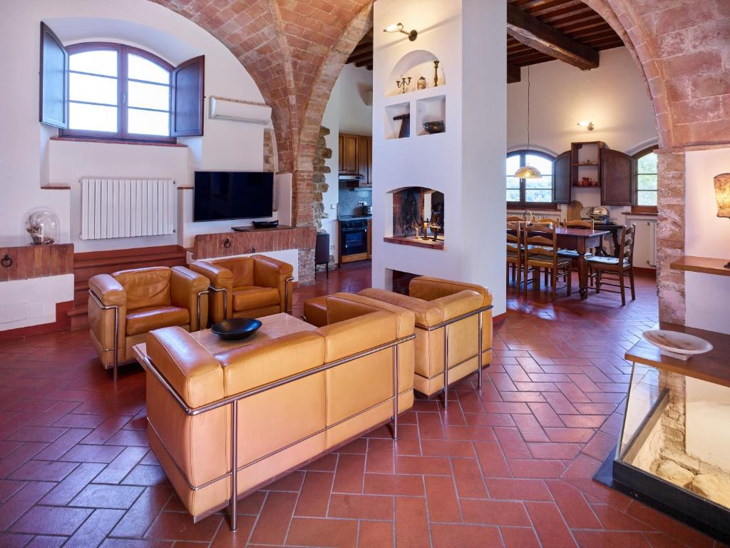 uma sala de estar com mobiliário de couro e uma sala de jantar em Agriturismo Podere Cortilla em Volterra