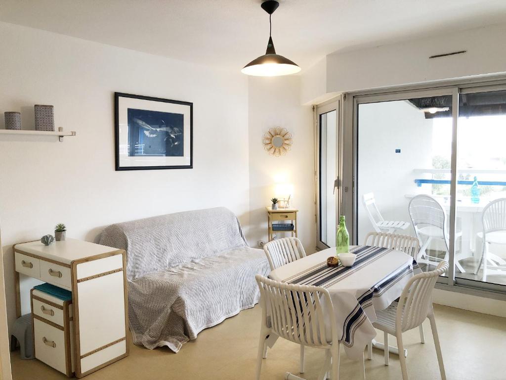 un salon avec un canapé, une table et des chaises dans l'établissement OCEALINE - Proche plages, Vue Salines - U71, à Carnac