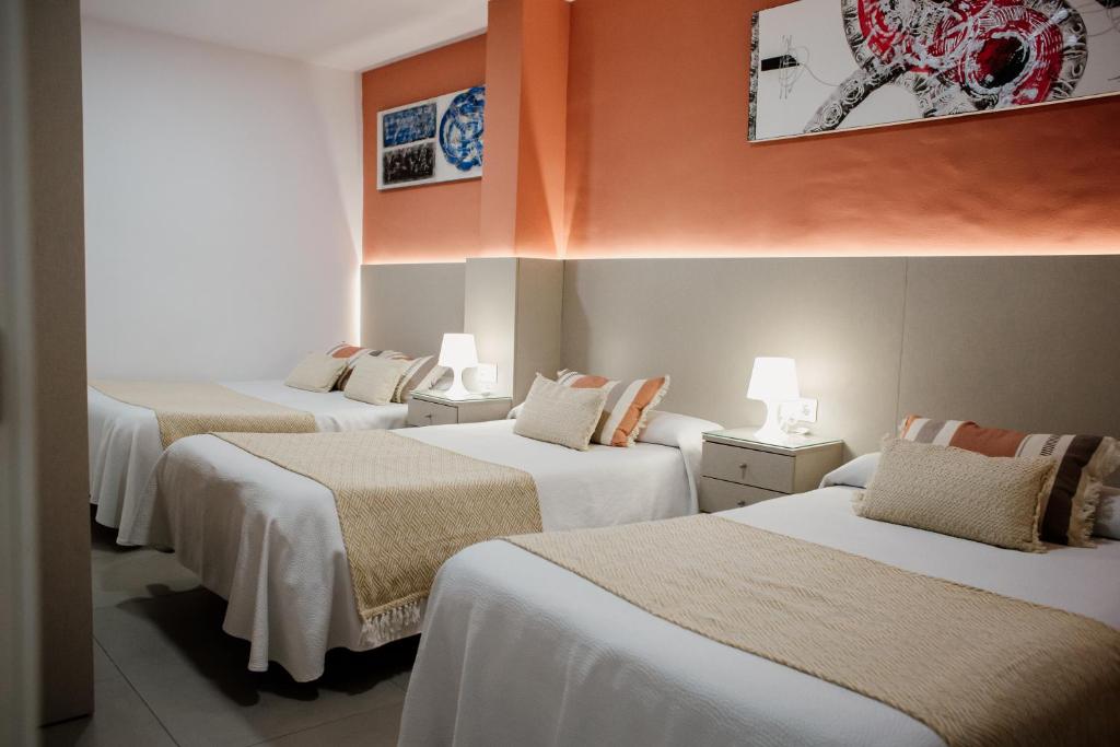Un grupo de 4 camas en una habitación en Pensión Mastil 16, en Málaga