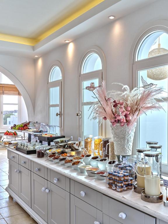a buffet of food in a room with windows at Stelia Mare Boutique Hotel in Naousa
