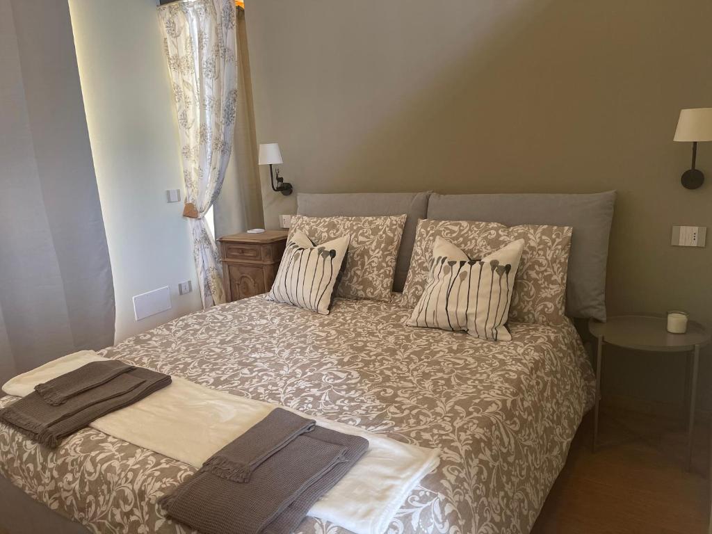 a bedroom with a bed with pillows on it at La Quintessenza del Borgo in Varzi