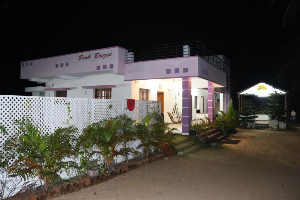 un gran edificio blanco con una valla delante en Royal Experience Pink Breeze Villa, Kuvathur ECR Highway Chennai, en Kūvattūr