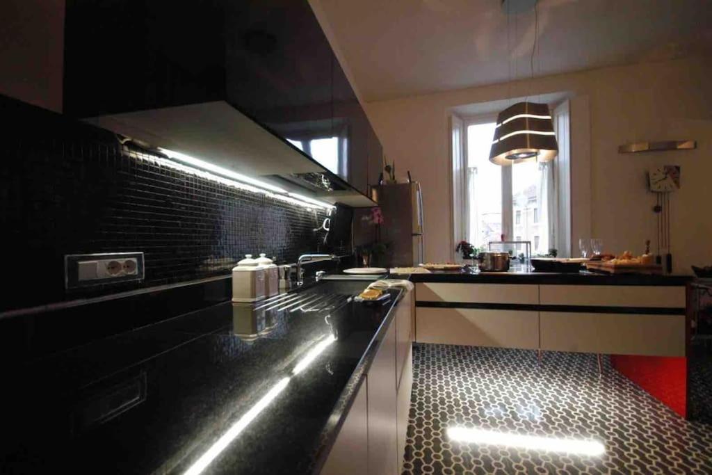 eine Küche mit einer schwarzen Arbeitsplatte in einem Zimmer in der Unterkunft Appartamento nel cuore di Asti in Asti