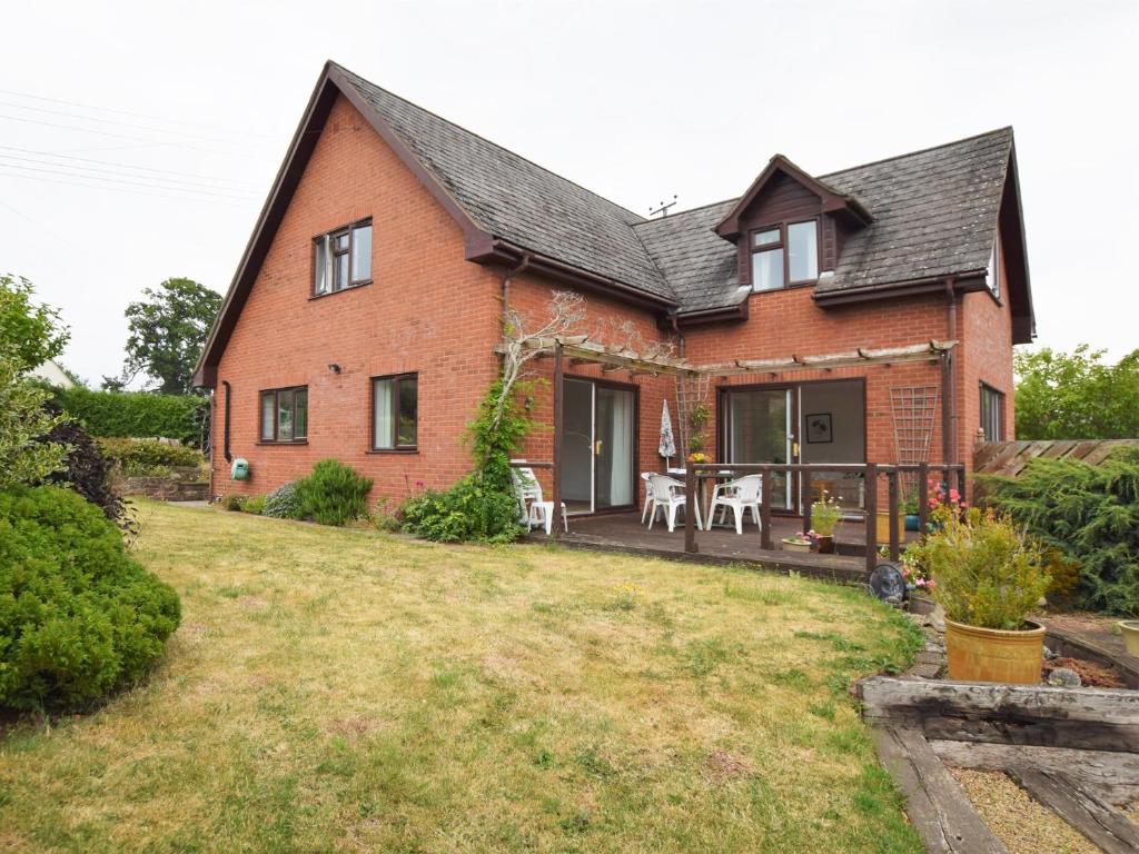 a red brick house with a patio and lawn at 3 bed in Ross-on-Wye 89313 in Peterstow