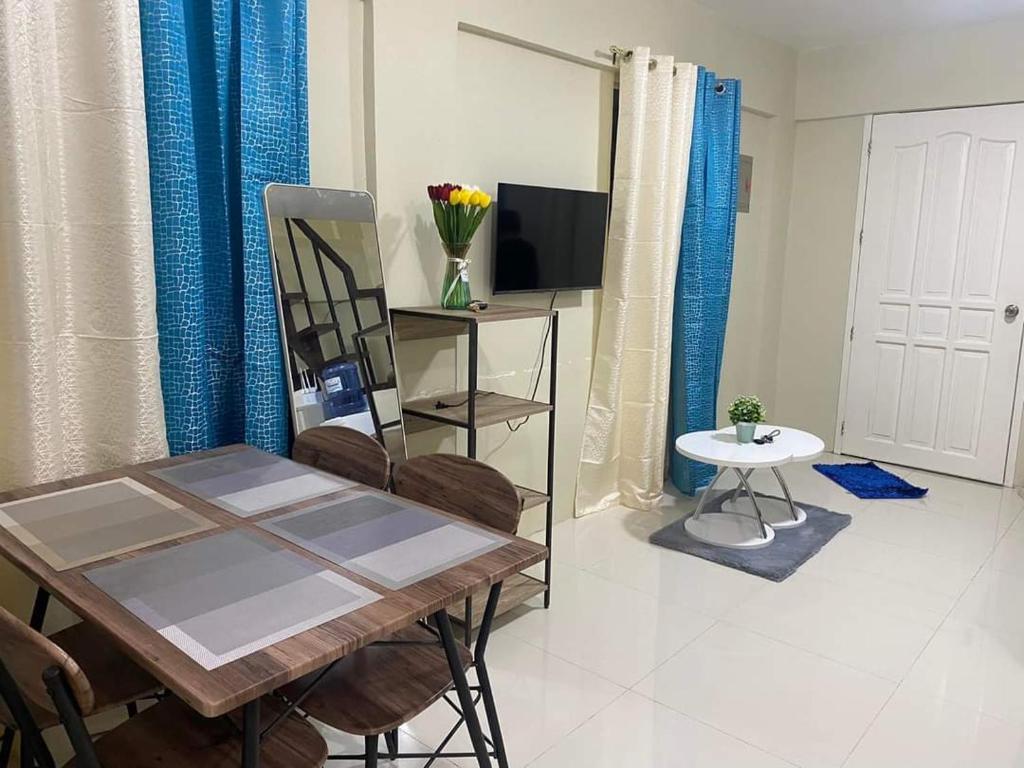 a dining room with a table and chairs and a television at Pagadian Staycation in Camella 1 in Pagadian
