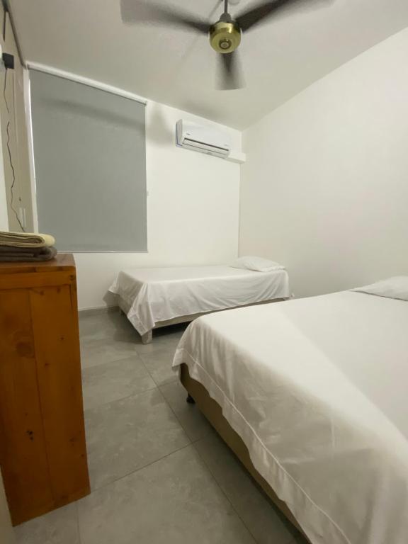 卡塔赫納的住宿－Apto Boho，一间卧室配有两张床和吊扇