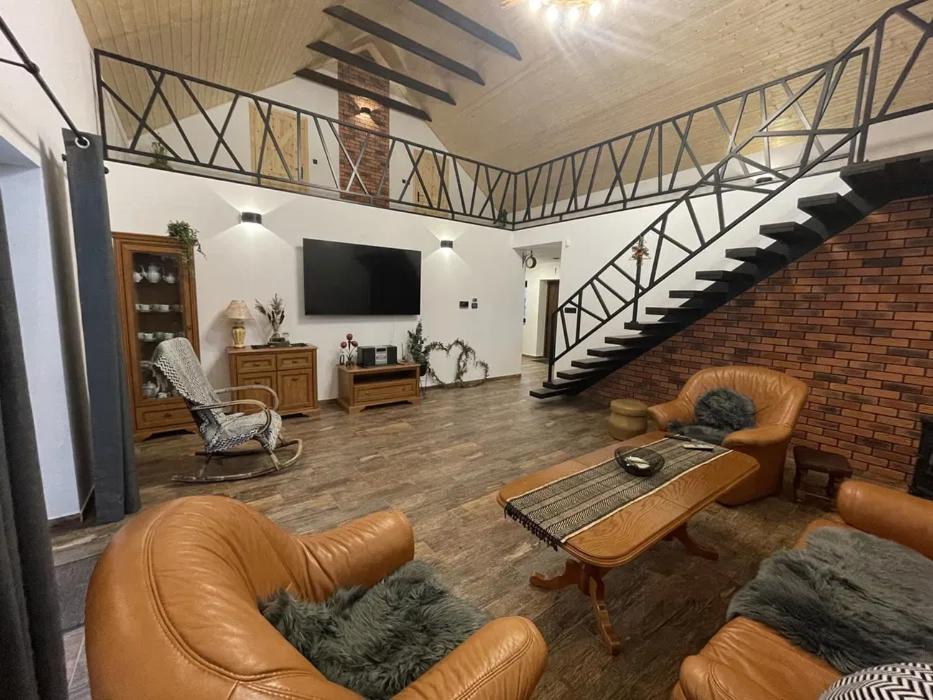 a living room with a couch and a table and stairs at Tajemniczy Ogród 