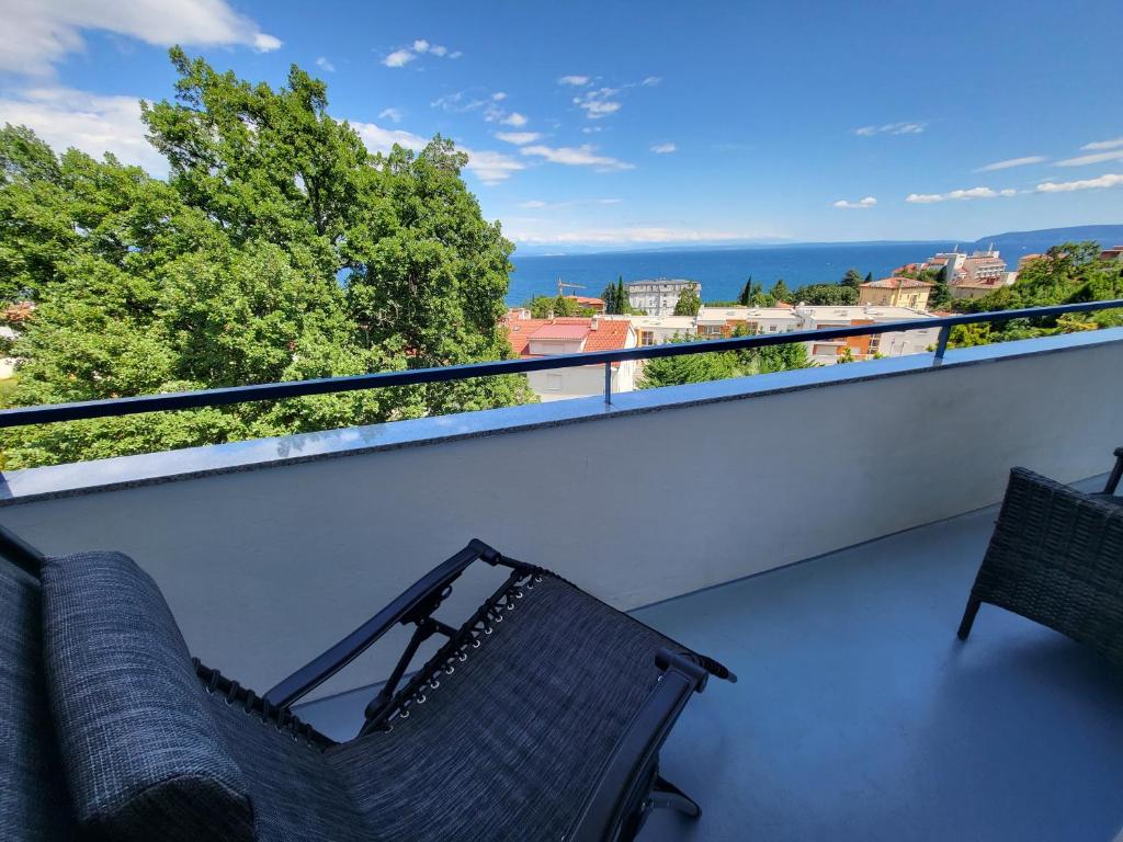 a balcony with two chairs and a view of the ocean at Apartment with direct Sea View, Free Parking and close to Beaches and Promenade in Lovran