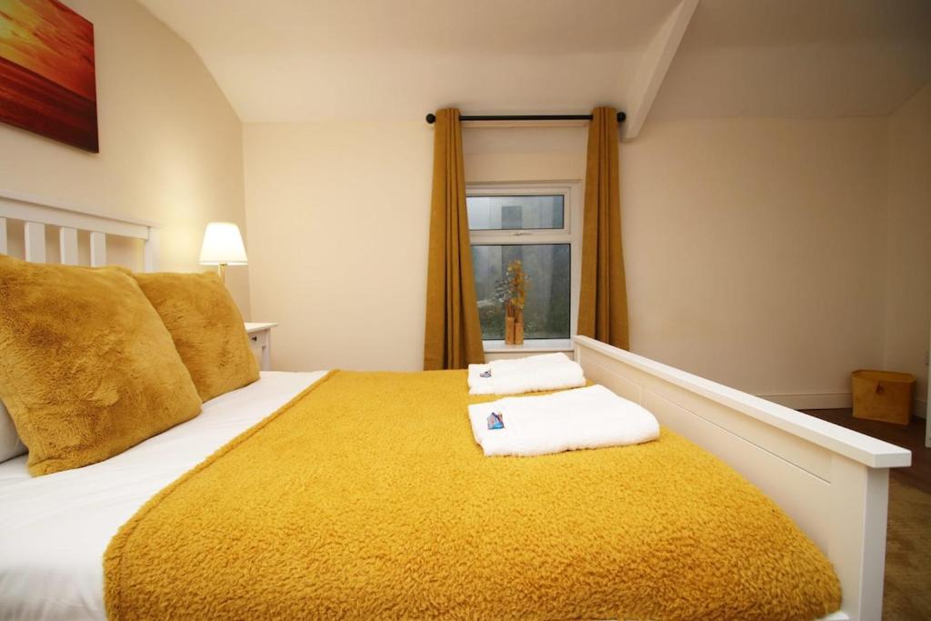 a bedroom with a large bed with towels on it at Llareggub by StayStaycations in Port Talbot