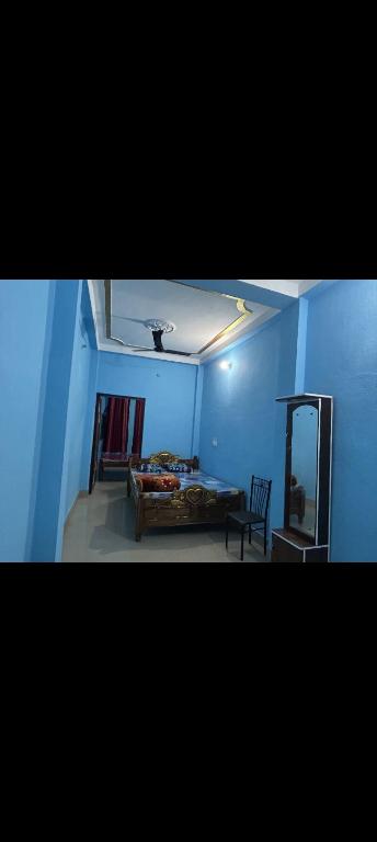 a blue room with a bed and a mirror at MAA MANSHA GUEST HOUSE in Deoghar