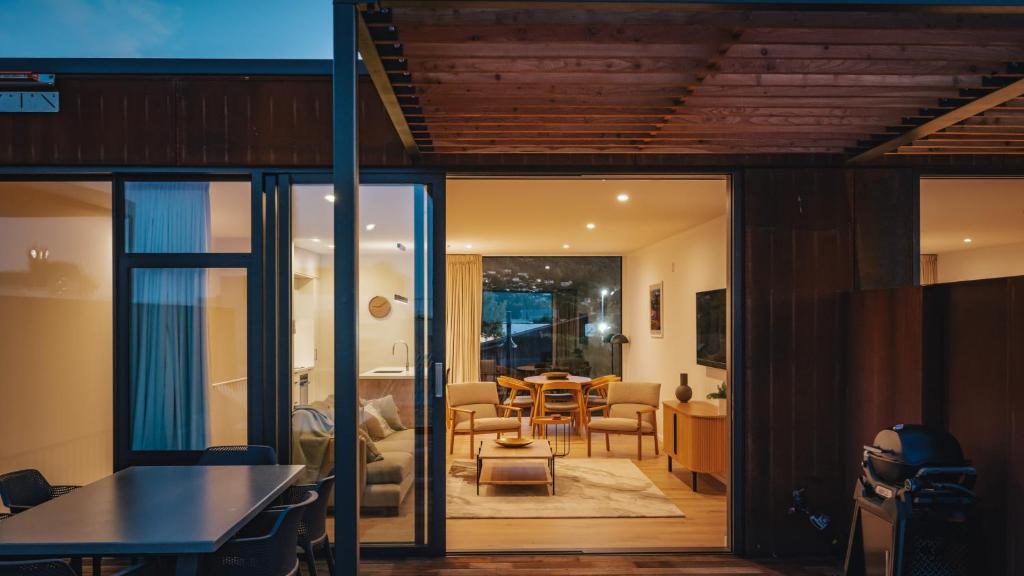 a living room with glass doors and a dining room at Beautiful urban apartment 2 in Nelson