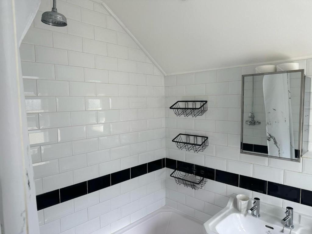 a white bathroom with a sink and a mirror at Eva Suites in Gillingham
