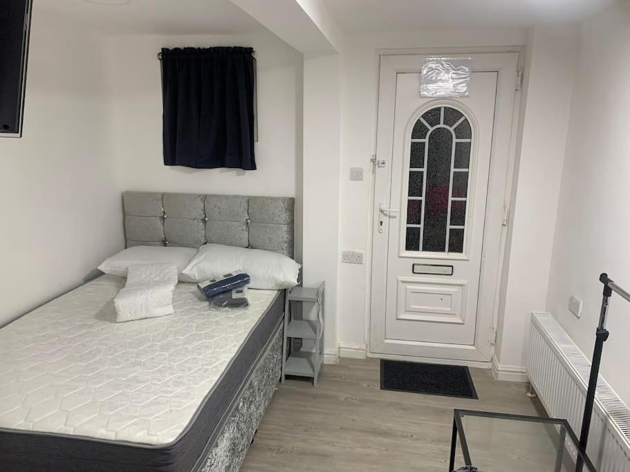 sypialnia z łóżkiem i białymi drzwiami w obiekcie Cosy Studio Flat-Just Renovated-Free Parking & Independent Entrance w mieście Hanworth
