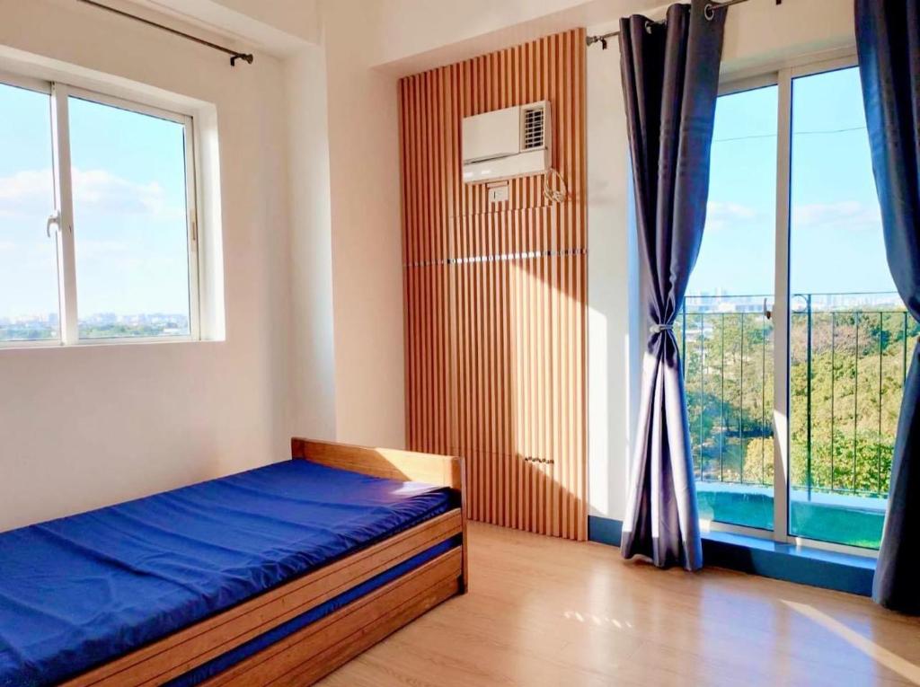 um quarto com uma cama e uma grande janela em Chateau Elysee Staycation Paranaque, Metro Manila em Manila