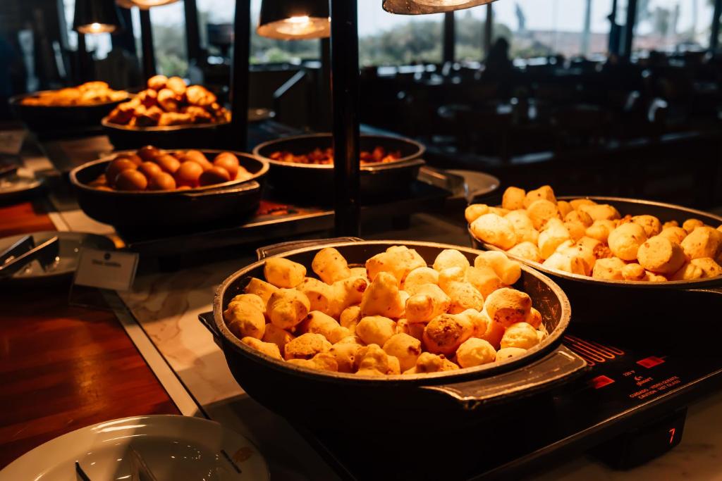 a buffet with several trays of food on display at Costao do Santinho Resort All Inclusive in Florianópolis