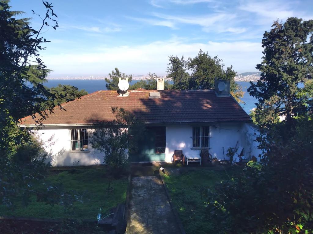 une maison blanche avec un chat assis sur le toit dans l'établissement naturel home, à Adalar