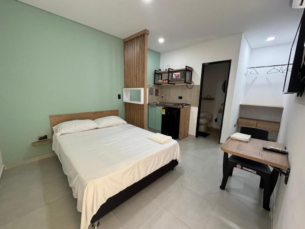 een slaapkamer met een bed, een tafel en een bureau bij Hotel Belalcazar Palmira in Palmira