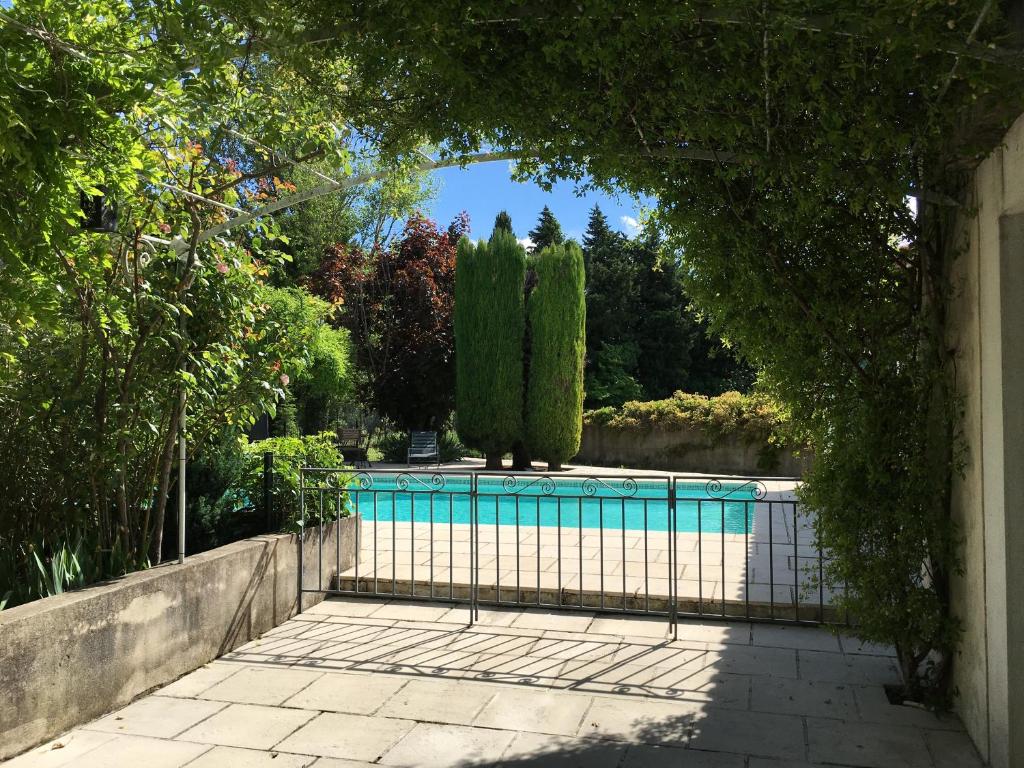 ein Torbogen, der zu einem Pool im Hof führt in der Unterkunft The Garden View in Le Thor