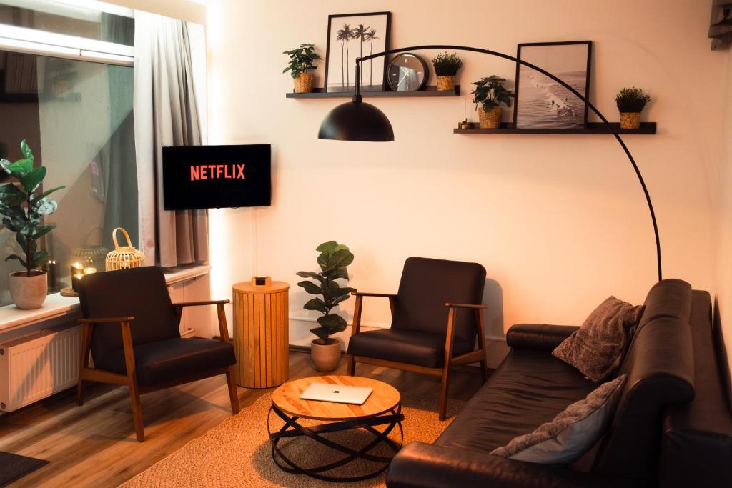 a living room with a couch and two chairs at Cozy FeWo mit Panoramablick in Sierksdorf