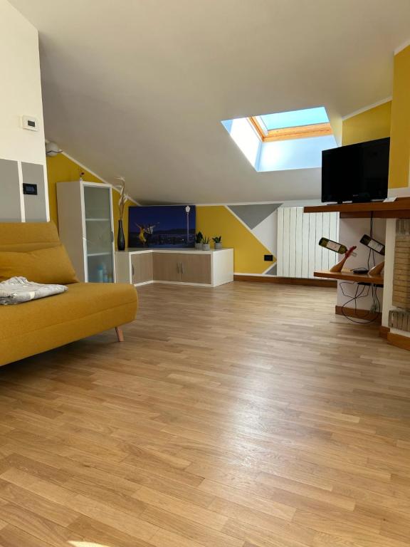 ein Wohnzimmer mit einem gelben Sofa und einem Dachfenster in der Unterkunft La La Home in Avezzano