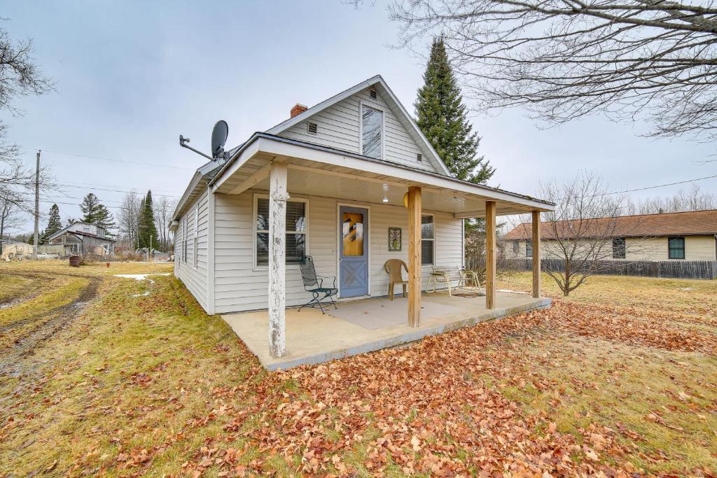 ein kleines weißes Haus mit einer Veranda auf einem Feld in der Unterkunft Peaceful Channing Retreat 3 Mi to Lake Access! 