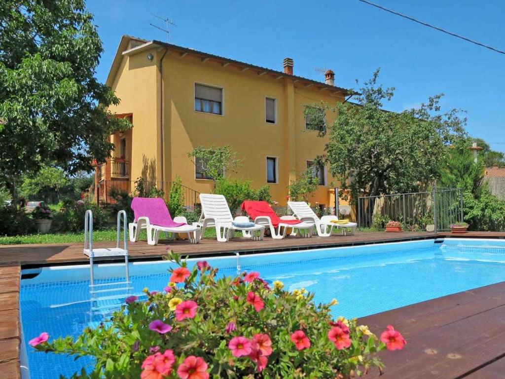 a house with a swimming pool with chairs and flowers at Pierotta Country House Arezzo in Laterina