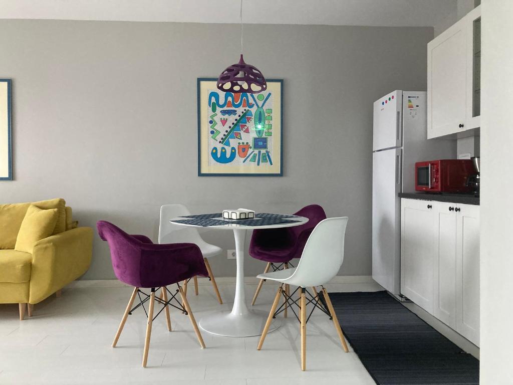 a dining room with a table and purple chairs at Apartamentul Max, practic și confortabil in Oradea