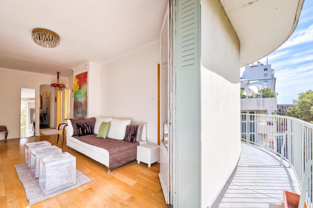 een woonkamer met een bank en een balkon bij Brienne by Yumē in Toulouse