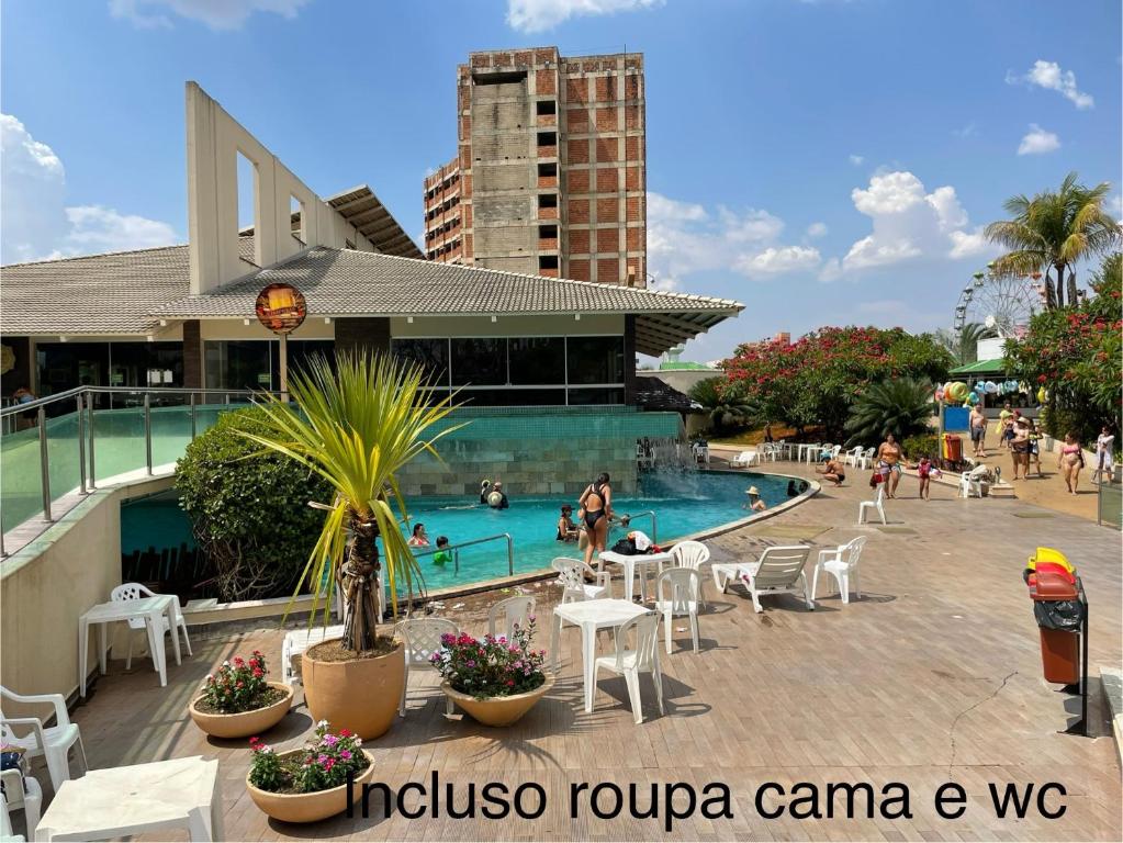 uma piscina num hotel com pessoas na água em Araras Apart Service I em Caldas Novas