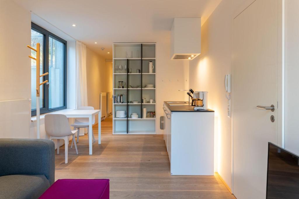 eine kleine Küche und ein Wohnzimmer mit einem Tisch und Stühlen in der Unterkunft Strandlust 21A Appartement in Wittdün