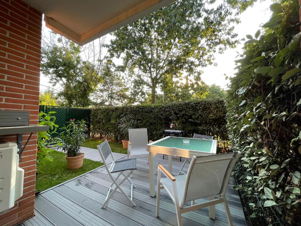 une terrasse avec une table de ping-pong et des chaises dans l'établissement Manoir by Yumē, à Toulouse
