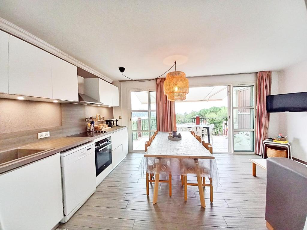 une cuisine avec une table et une salle à manger dans l'établissement 3 pièces tout confort à Cap Estérel, à Saint-Raphaël
