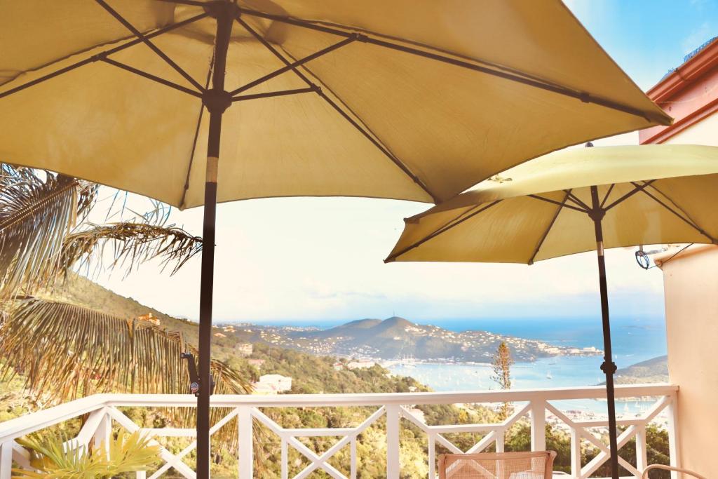 two yellow umbrellas on a balcony with a view of the ocean at Northside Studio Vacation Rental in Nazareth