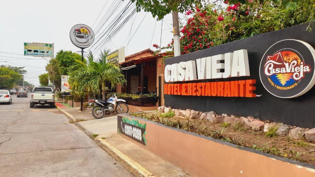 una señal para un restaurante al lado de una calle en Casa Vieja Hotel y Restaurante en San Lorenzo