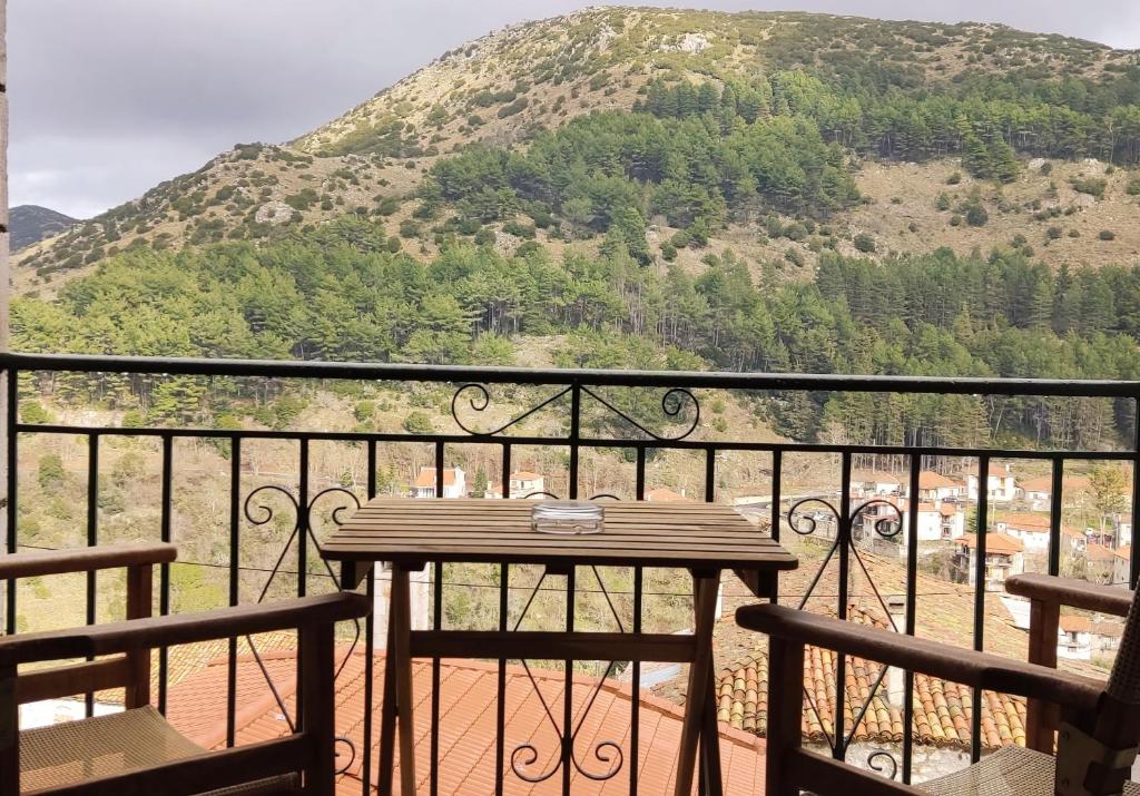 a table on a balcony with a mountain in the background at Kristis's Homes - "Beautiful Home" in Dimitsana in Dimitsana