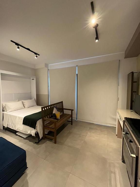 een slaapkamer met een bed en een bank in een kamer bij Loft Alto Padrão Moderno - VN Capote in Sao Paulo