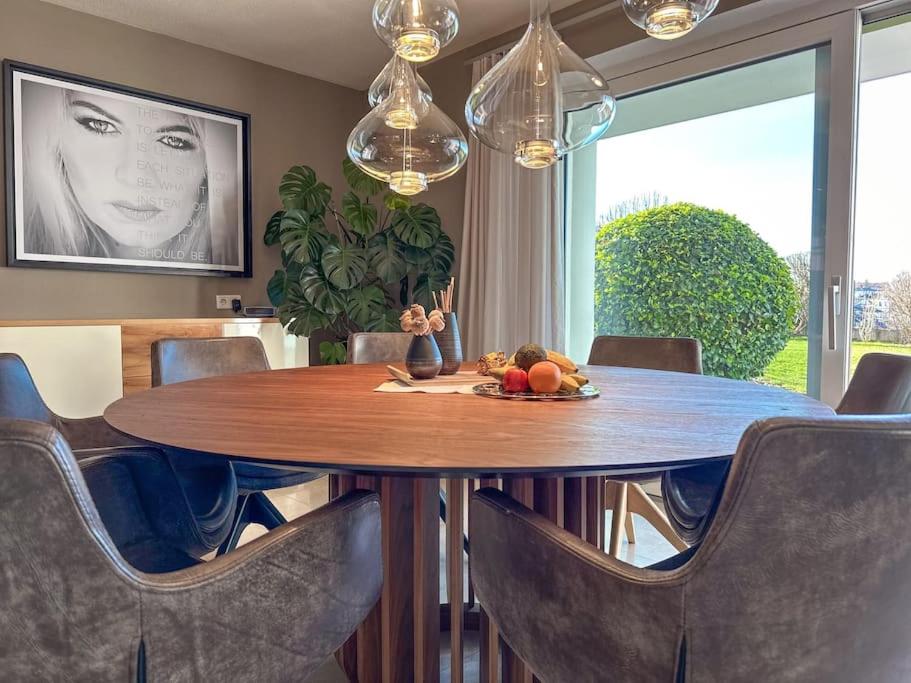 a dining room with a wooden table and chairs at LIEBLINGSPLATZ, elegant apartment, countryside in Seekirchen am Wallersee